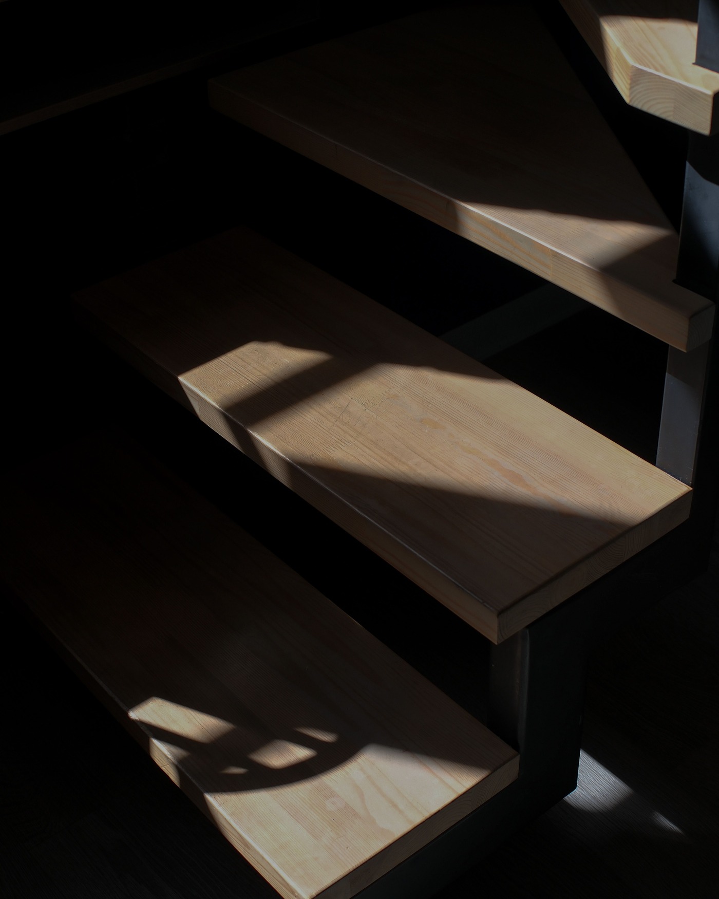 Escalera interior de madera con sombras marcadas